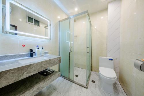 昆明曼朵酒店(昆明长水国际机场店)的一间带卫生间和玻璃淋浴间的浴室