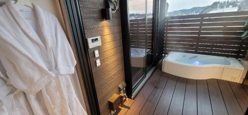 高山ROMANSTAY的一间位于窗户旁的带浴缸的浴室