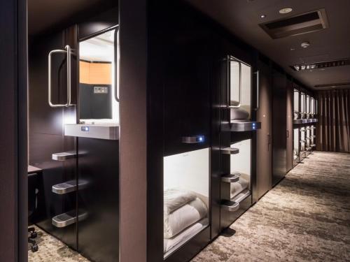 京都京都河原町格兰希特胶囊旅馆的客房设有带一张床和镜子的卧室