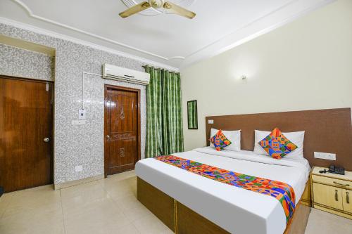 新德里FabExpress Smart Stay的卧室配有一张带彩色枕头的大型白色床。