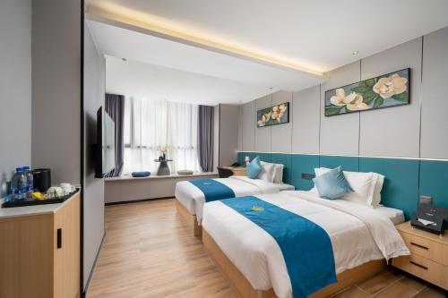 深圳维展湾酒店(深圳国际会展中心店)的蓝色和白色的客房内的两张床