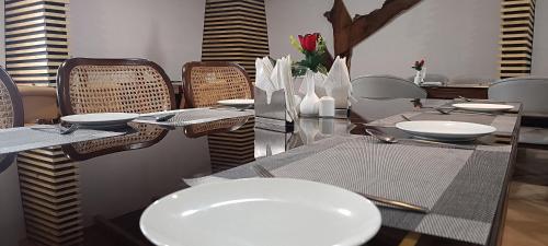 PithorāgarhHOTEL GRP INN CITY HOME的用餐室配有带白板和椅子的桌子
