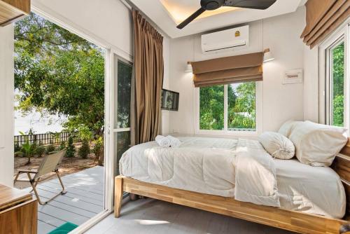 苏梅岛Brand New Beachfront & Secluded Tiny House的一间带大床的卧室和一个阳台