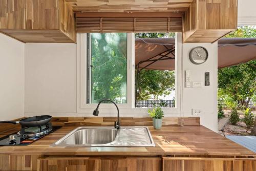 苏梅岛Brand New Beachfront & Secluded Tiny House的厨房设有水槽和窗户。