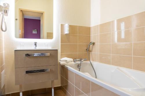 Plurien伯恩卡普酒店的带浴缸、水槽和镜子的浴室