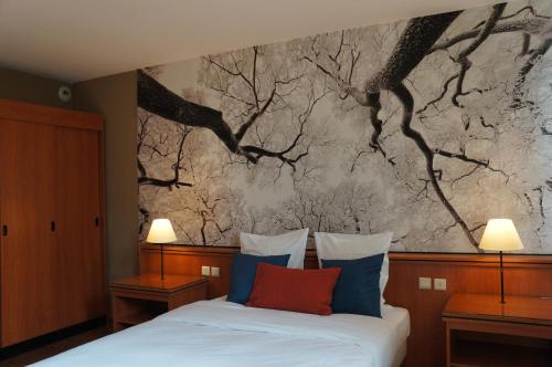 布鲁塞尔埃斯卡勒酒店的一间卧室配有一张壁画床