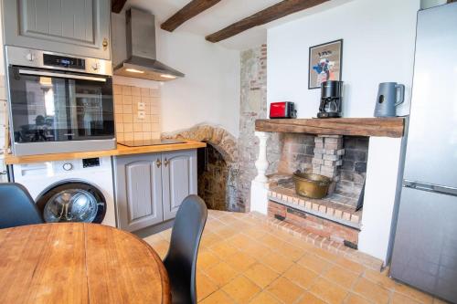 阿姆博斯Le Charme Authentique d'Amboise的厨房配有桌子、炉灶和壁炉。
