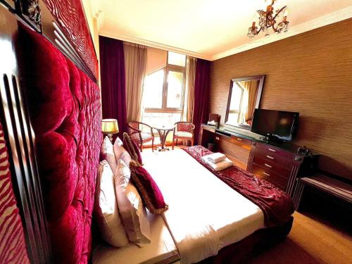 贝鲁特皇后套房酒店的一间卧室配有一张大床和电视