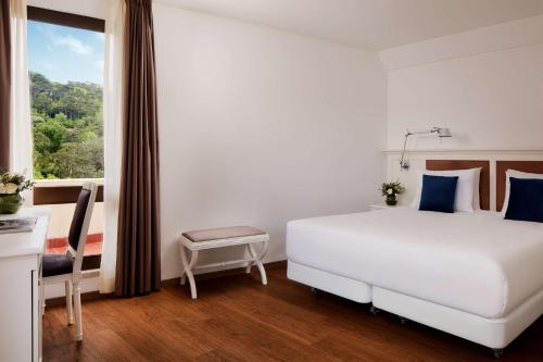 辛特拉NH Sintra Centro的卧室设有一张白色大床和一扇窗户。