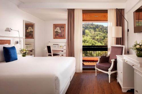 辛特拉NH Sintra Centro的酒店的客房 - 带一张床、椅子和窗户