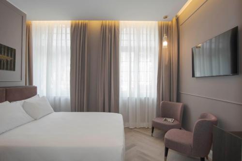 罗马维米纳勒酒店的配有一张床和一把椅子的酒店客房