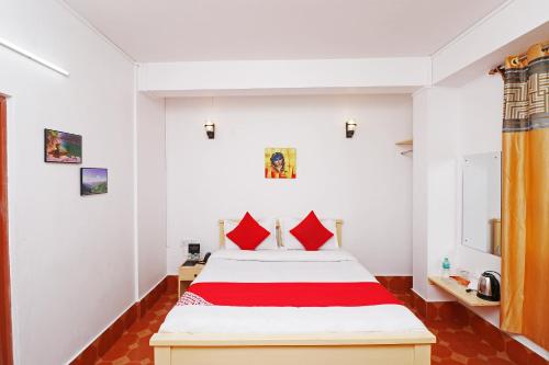 西隆Bamon Homestay的一间卧室配有一张带红色枕头的大床