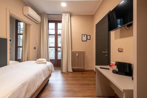 都灵Torino Station Relais的一间卧室配有一张大床和电视