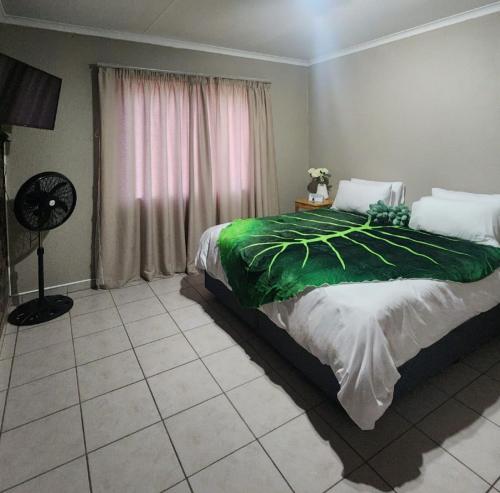 博克斯堡OR Tambo Int Airport Rudman B Self Catering Two Bedroom Home的一间卧室配有一张带绿毯的床