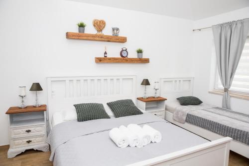 兹诺伊莫Apartmány Ellie的白色卧室 - 带两张床和毛巾