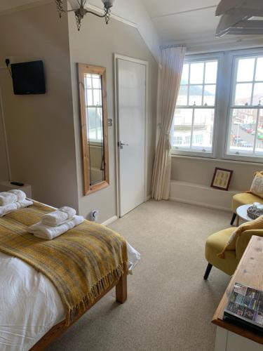 伊斯特布恩Gyves House的一间卧室配有一张床、一张沙发和窗户。
