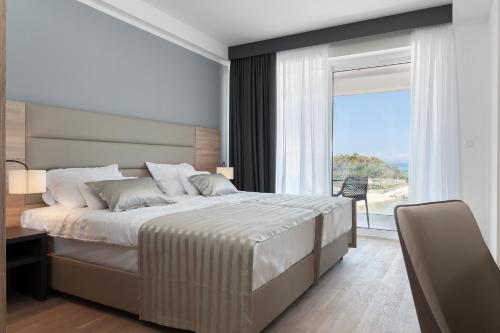 诺瓦利娅Kaneo beach hotel Novalja的一间卧室设有一张大床和一个大窗户