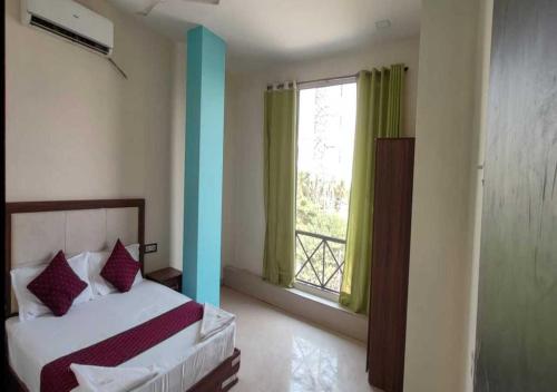 孟买Hotel Blue Sky Residency的一间卧室设有一张床和一个大窗户