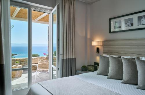 洛加拉斯Summer Senses Luxury Resort的一间卧室配有一张床,享有海景