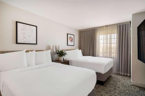 SorrentoSonesta ES Suites San Diego - Sorrento Mesa的酒店客房设有两张床和电视。