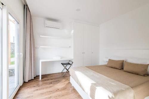 蓬塔德尔加达Vilas do Olival的白色的卧室设有床和窗户