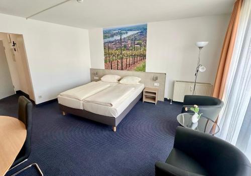 沃尔姆斯阿斯伽德酒店的卧室配有一张床,墙上挂有绘画作品