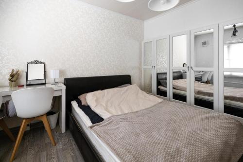 凯拉瓦Talo Kerava的一间卧室配有一张床、一张桌子和一把椅子