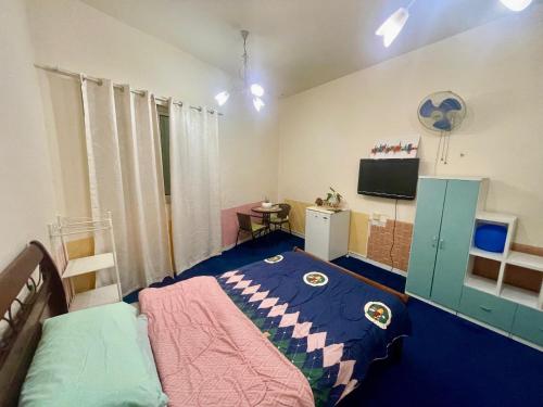 迪拜Salahuddin Metro Home Stay的一间卧室配有一张床和一台电视。