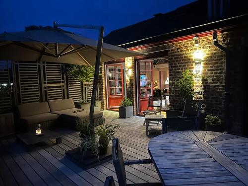 Dion-le-MontMaison cosy的一个带遮阳伞和家具的木制甲板