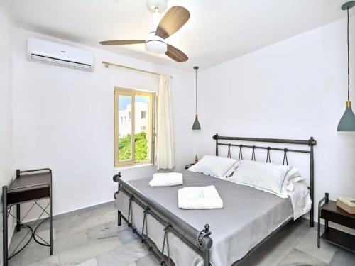 纳乌萨Villa Maria - Naoussa Boats Blue & Sandy Suite的一间卧室配有一张床和吊扇