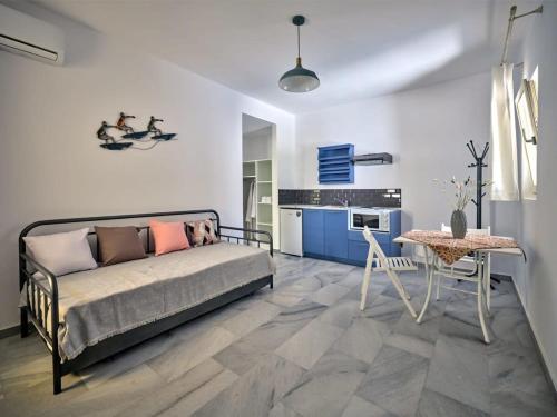 纳乌萨Villa Maria - Naoussa Surfers Bluewave Suite的一间卧室配有一张床铺和一张桌子,还设有一间厨房