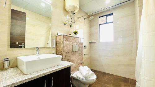 古尔冈ZEN Suites - Golf Course Road Gurgaon的一间带水槽和卫生间的浴室