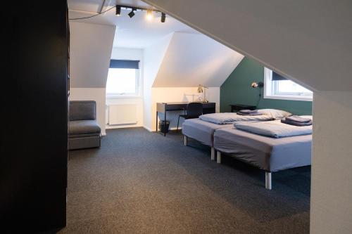 努克Kulukis Downtown Hostel的一间卧室配有两张床、一张桌子和一把椅子