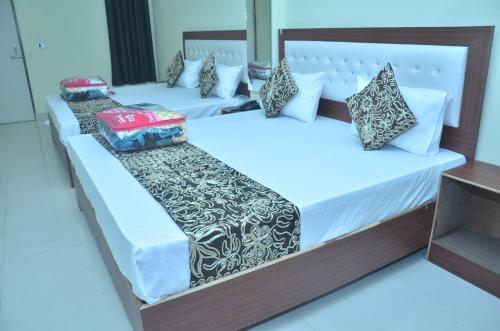 阿格拉Divine sparrow family homestay的配有2张床的带白色床单和枕头的客房