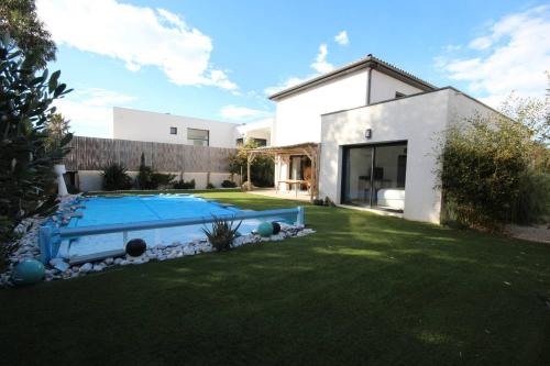 波尔蒂拉盖Belle villa contemporaine climatisee, piscine privee, 6 - 8 couchages, 3 chambres, wifi, à 3 km de la plage -LXDALI25B的庭院中带游泳池的房子