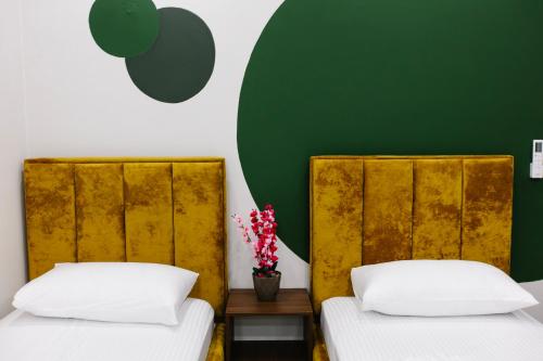都拉斯Andor Luxury Hotel的绿墙客房的两张床