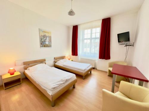 格尔利茨潘森匹克贝罗酒店的客房设有两张床、一张桌子和一台电视机。