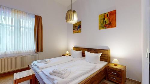 宾茨Residenz Prorer Wiek的一间卧室配有一张带白色床单的床和一扇窗户。
