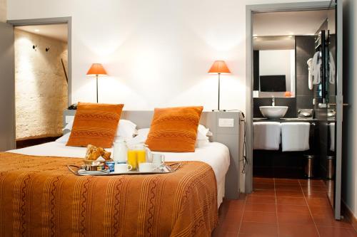 阿维尼翁克鲁尔特圣路易斯阿维农酒店的一间酒店客房,配有一张床铺,上面放着一个食物托盘