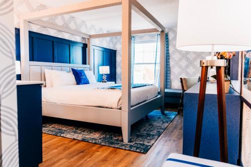 塞伦塞勒姆海滨酒店及套房的一间卧室配有一张天蓬床和蓝色的墙壁