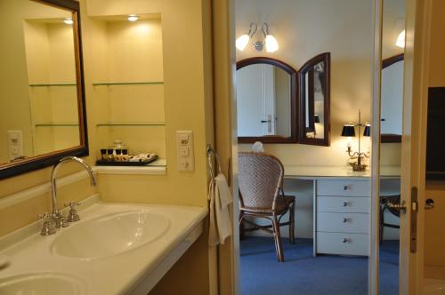 伯尔尼内恩格独特酒店的一间带水槽的浴室和一张带椅子的桌子
