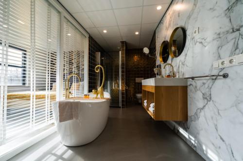 瓦赫宁根Hotel WICC的一间带大浴缸和水槽的浴室