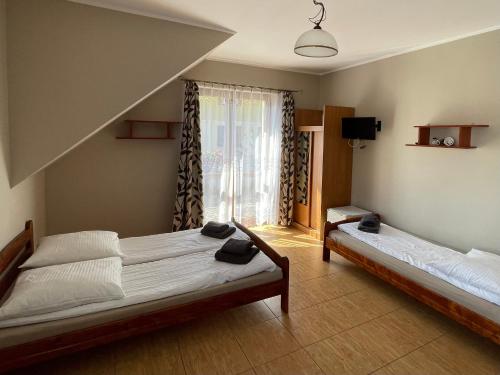 德布吉Diuna的一间卧室设有两张床和窗户。