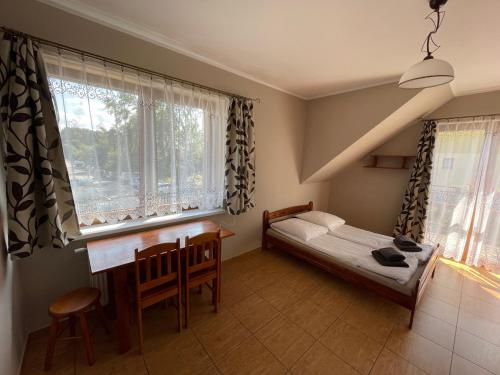 德布吉Diuna的一间卧室配有一张床、一张书桌和一个窗户。