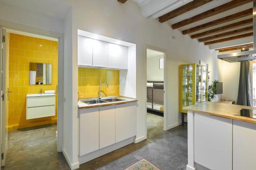 巴塞罗那64 Apartment in a typical Barcelona's old building的厨房配有白色橱柜和黄色瓷砖