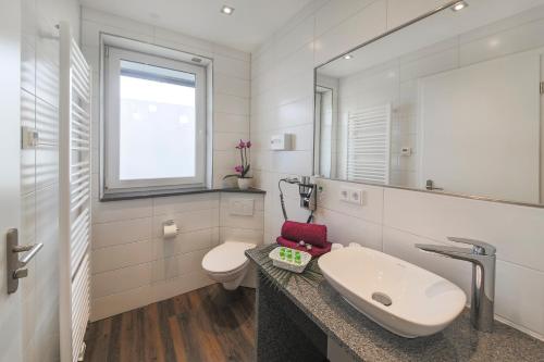 腓特烈港Hotel Gästehaus Stock的白色的浴室设有水槽和卫生间。