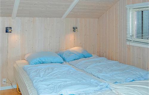 海耶斯Stunning Home In Sjlund With House Sea View的一张位于带蓝色床单和枕头的客房的床位
