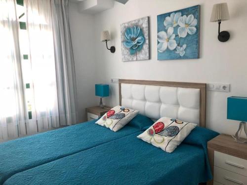 莫甘海滩Billy's Puerto de Mogán Apartments by LIVVO的一间卧室配有蓝色的床和两个枕头