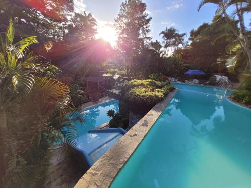 特里温福Pousada Baixa Verde的花园内的游泳池,阳光充足