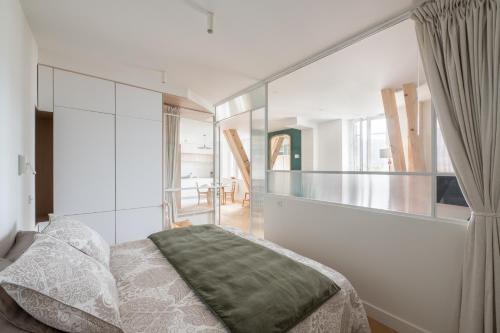 艾克斯莱班Les Suites du Bernascon - Appartement 4 étoiles的一间卧室设有一张床和玻璃墙